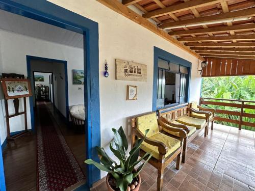 a living room with chairs and a room with a porch at Sítio São Pedro in São Bento do Sapucaí