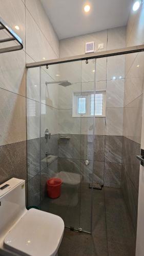 a bathroom with a glass shower with a toilet at Uthuppan's 2 bedroom first floor in Ūdumbanshola
