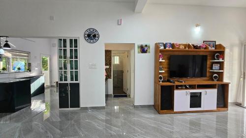 a living room with a television and a kitchen at Uthuppan's 2 bedroom first floor in Ūdumbanshola