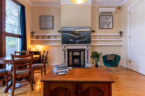 a living room with a table and a fireplace at Peaceful and Stylish Petersham Aparttment with Parking in Sydney