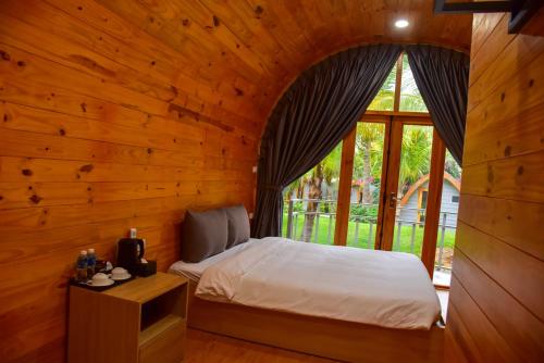 a bedroom with a bed in a room with a window at The Vista Beach Resort Phan Thiết in Phan Thiet