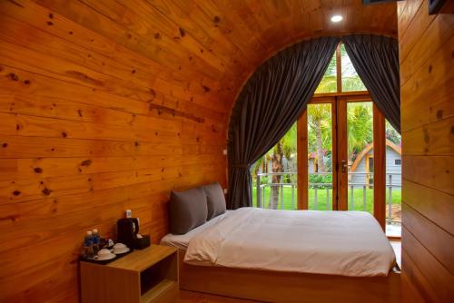 a bedroom with a bed in a wooden wall at The Vista Beach Resort Phan Thiết in Phan Thiet