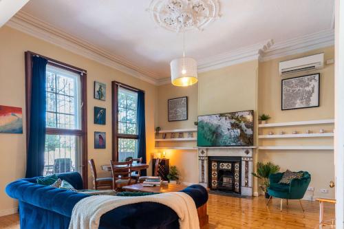 a living room with a blue couch and a fireplace at Peaceful and Stylish Petersham Aparttment with Parking in Sydney