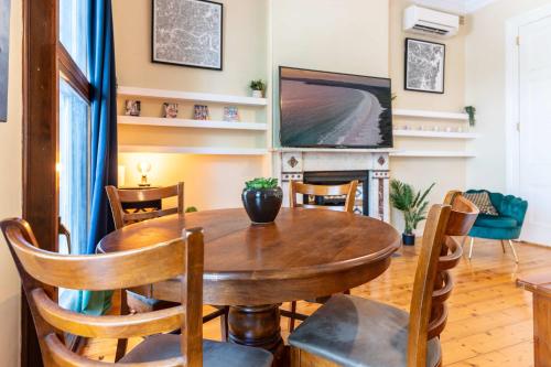 a dining room with a wooden table and a tv at Peaceful and Stylish Petersham Aparttment with Parking in Sydney