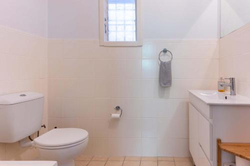 a white bathroom with a toilet and a sink at Peaceful and Stylish Petersham Aparttment with Parking in Sydney