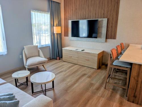 a living room with a tv and a couch and a table at Sea Glass Beach Place, Trademark Collection by Wyndham in Fort Lauderdale