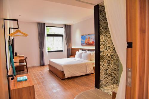 a hotel room with a bed and a mirror at The Vista Beach Resort Phan Thiết in Phan Thiet