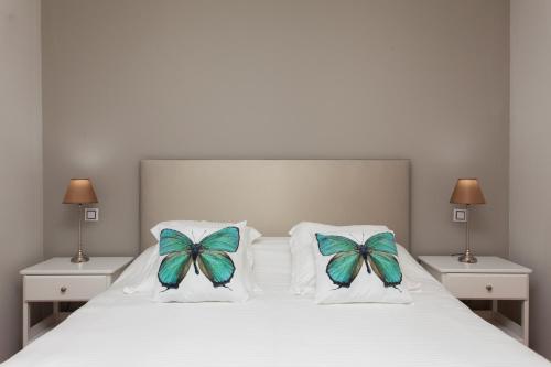 1 dormitorio con 1 cama con 2 mariposas en las almohadas en Villa con Piscina ,Vista Mar y campo de golf, en Caleta de Fuste