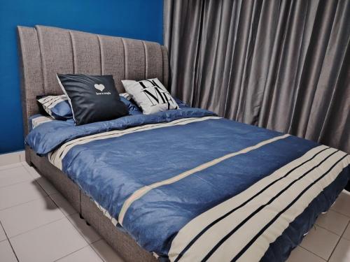 a bed with a blue comforter and pillows on it at 马六甲Travel Serindik in Melaka