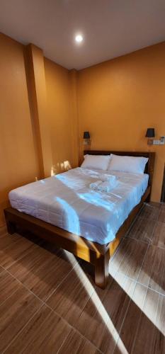 a bedroom with a large bed with blue sheets at Baansuan Tham Ma Chad Homestay in Suphan Buri