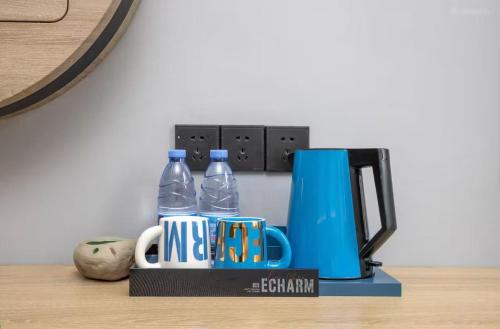 a coffee maker and two bottles of water on a table at Echarm Hotel Chengdu Dujiangyan Scenic South Bridge in Chengdu