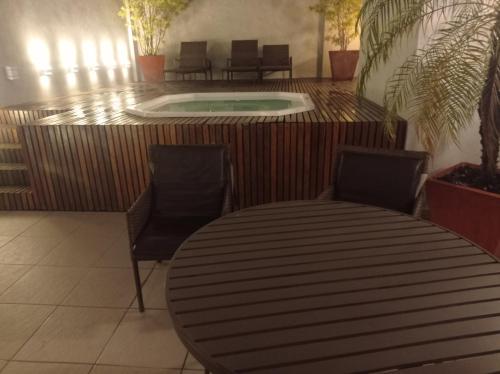 a round table with two chairs and a swimming pool at Flat temporada in Campos dos Goytacazes