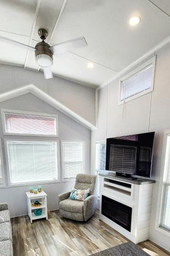 a living room with a flat screen tv and a chair at Happy in the Keys Tiny Home in Key Largo