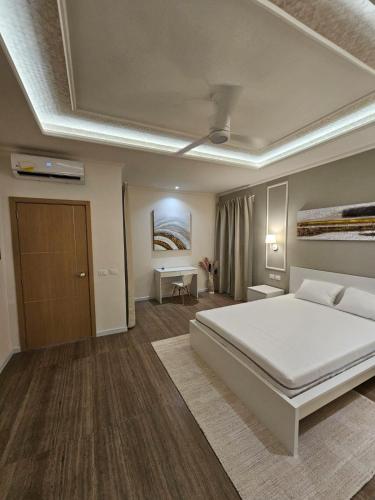 a bedroom with a large white bed and a desk at Soficu Hotel El Edén Dominicus in Bayahibe