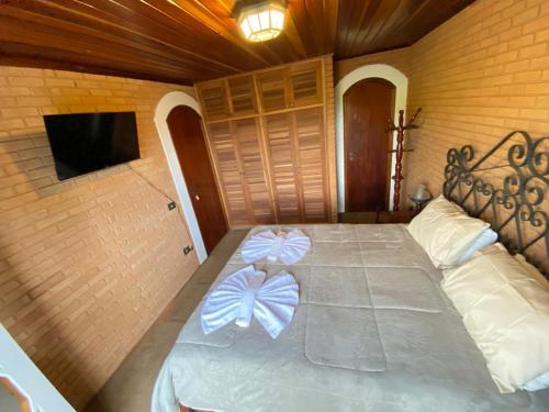 Un dormitorio con una cama con dos arcos encima. en Refugio maná, en Campos do Jordão