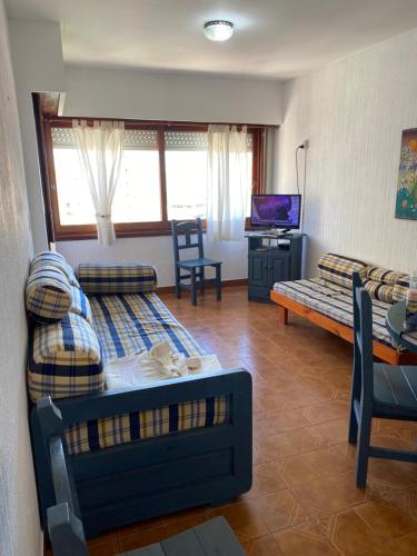 una sala de estar con un sofá y una mesa en Romeo 4, en Villa Gesell