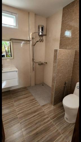 a bathroom with a shower and a toilet and a sink at Baansuan Tham Ma Chad Homestay in Suphan Buri