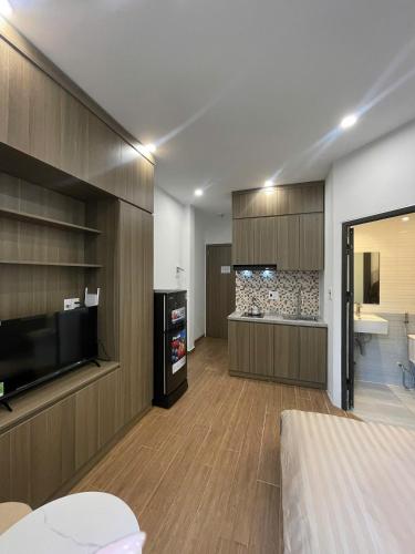 a living room with a television and a bathroom at Era Apartment - Chùa Láng in Hanoi