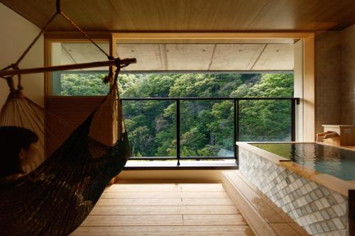 a hammock in a room with a large window at Sakunami Onsen Yuzukushi Salon Ichinobo in Sendai