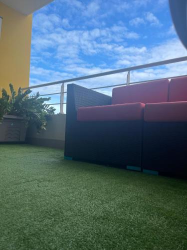 a balcony with a red couch on a balcony at Papeete studio Keahaia in Papeete