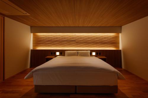 a bedroom with a large bed with a window at Sakunami Onsen Yuzukushi Salon Ichinobo in Sendai