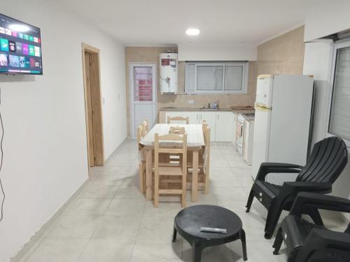 Una cocina con mesa y sillas y un refrigerador. en Residencia Los Miottis, en Necochea
