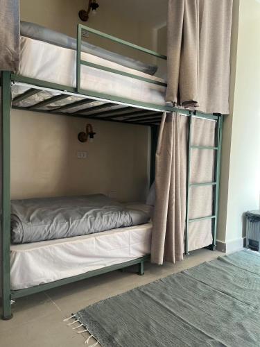 a bedroom with two bunk beds with a window at Green hostel in Cairo