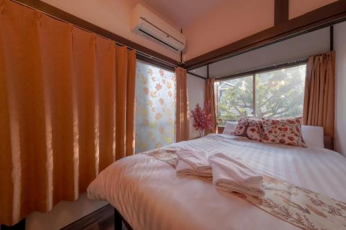 a bedroom with a bed and a large window at サンライズ田端新町ハウス in Tokyo