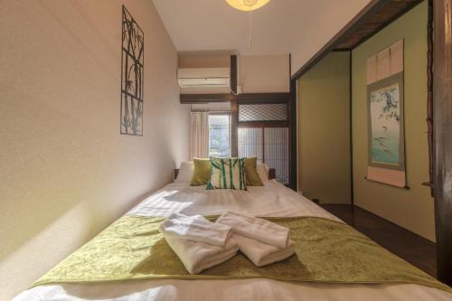 a bedroom with a bed with two towels on it at サンライズ田端新町ハウス in Tokyo