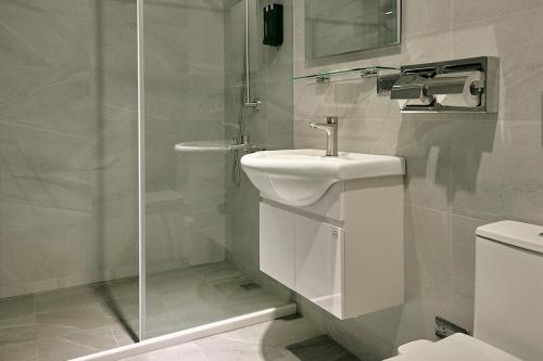 a white bathroom with a sink and a shower at Qingyu B&B in Luzhu
