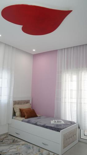 a bedroom with a bed with a red painting on the ceiling at Golden view in Rrushkull