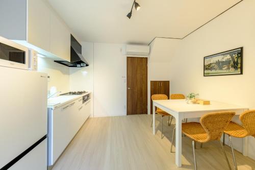 a kitchen and dining room with a white table and chairs at Cozy 2-Floor Retreat near Ikebukuro - Easy Access to Central Tokyo - アキサポステイ本蓮沼 in Tokyo