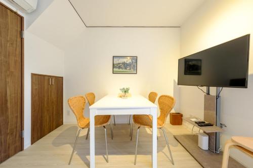 a dining room with a white table and chairs at Cozy 2-Floor Retreat near Ikebukuro - Easy Access to Central Tokyo - アキサポステイ本蓮沼 in Tokyo