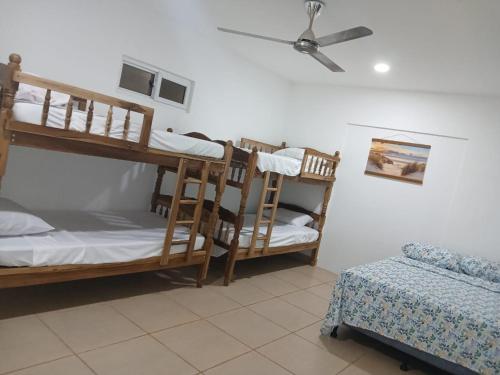 a room with two bunk beds and a ceiling fan at Rancho Joya Del Mar in Sonsonate