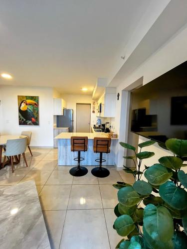 a kitchen with two bar stools and a counter at Top-floor overlooking uptown with AC & parking in San José