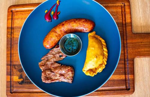 a blue plate of food with meat and sausage at Top-floor overlooking uptown with AC & parking in San José