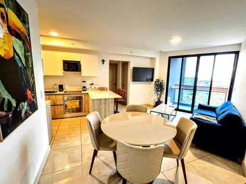 a living room with a table and a kitchen at Top-floor overlooking uptown with AC & parking in San José