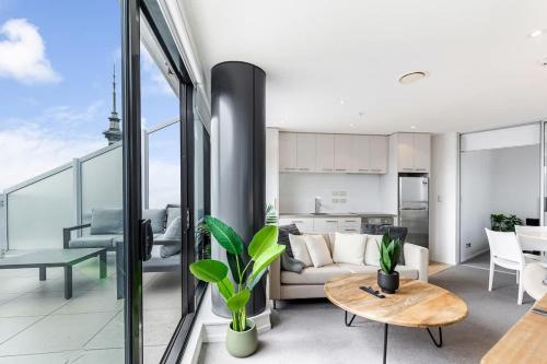 a living room with a couch and a table at Pool, Gym & Modern 2BR Sky Tower View Zodiak Stays in Auckland