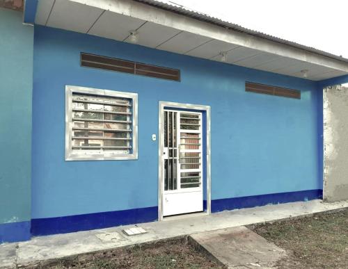 a blue building with a door and a window at Hogar y naturaleza in Iquitos
