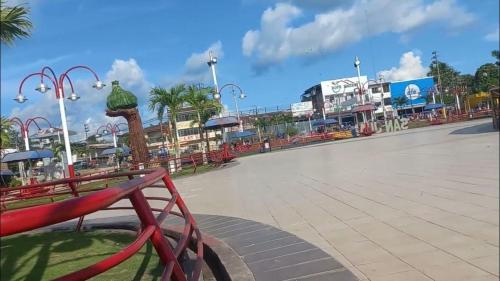 a park with a red bench in front of a street at Hogar y naturaleza in Iquitos