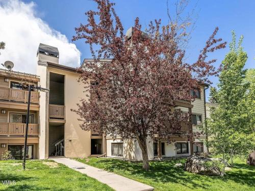 an apartment building with a tree in front of it at Beaver Creek, Avon condo, walk to ski shuttle - on the Eagle River in Avon