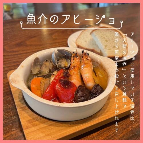 a bowl of food with vegetables and bread on a table at ペンションニライカナイ NiraiKanai in Awaren