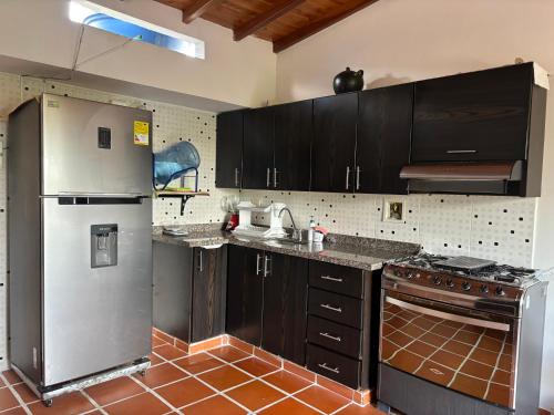 a kitchen with stainless steel appliances and brown cabinets at Apartamento en Bucaramanga in Bucaramanga
