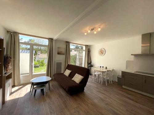 un salon avec un canapé et une table dans l'établissement Maison charmante 4 pers. calme, proche forêt, terrasse, parking - FR-1-323-560, à Saint-Jean-de-Monts