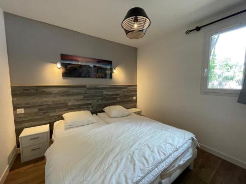 une chambre avec un lit blanc et une fenêtre dans l'établissement Maison charmante 4 pers. calme, proche forêt, terrasse, parking - FR-1-323-560, à Saint-Jean-de-Monts