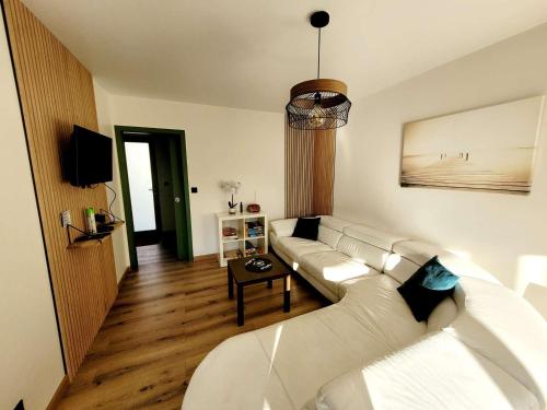 un salon avec un canapé blanc et une table dans l'établissement Maison 3 chambres jardin parking proche plage, WIFI, animaux acceptés - FR-1-675-43, à Wimereux