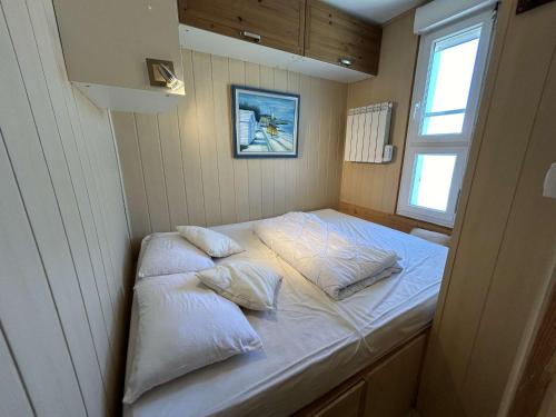 - un lit dans une petite chambre avec 2 oreillers dans l'établissement Appartement 3 pièces cabine avec balcon, 6 couchages à Saint-Jean-de-Monts - FR-1-224C-330, à Saint-Jean-de-Monts