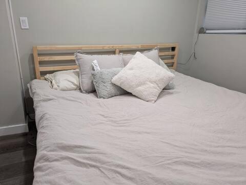 a bed with white sheets and pillows on it at Jetted Tub Stay in Passaic