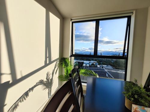 a balcony with a table and chairs and a window at Auckland Birkenhead BNB in Auckland