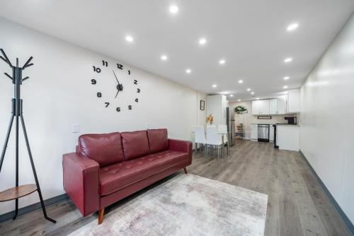 a living room with a red couch and a clock on the wall at Jetted Tub Stay in Passaic